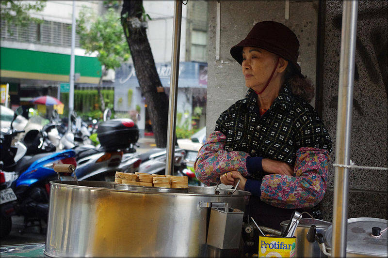 a woman is waiting for the customer to buy her food